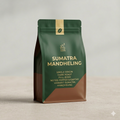 Green and brown coffee bag with 'Sumatra Mandheling' text on a light gray background